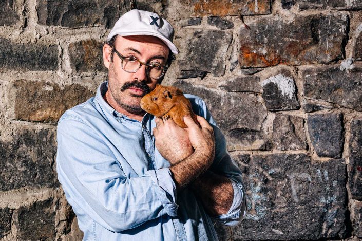 Sam Simmons holding a ginger hamster