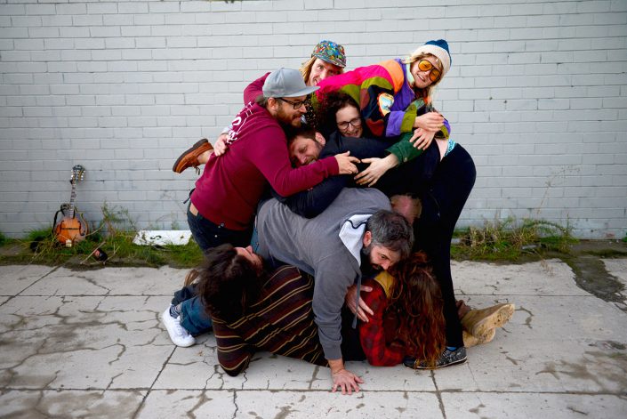 Sunday Music – Salary Band member pilled up on the ground on top of each other, horsing around