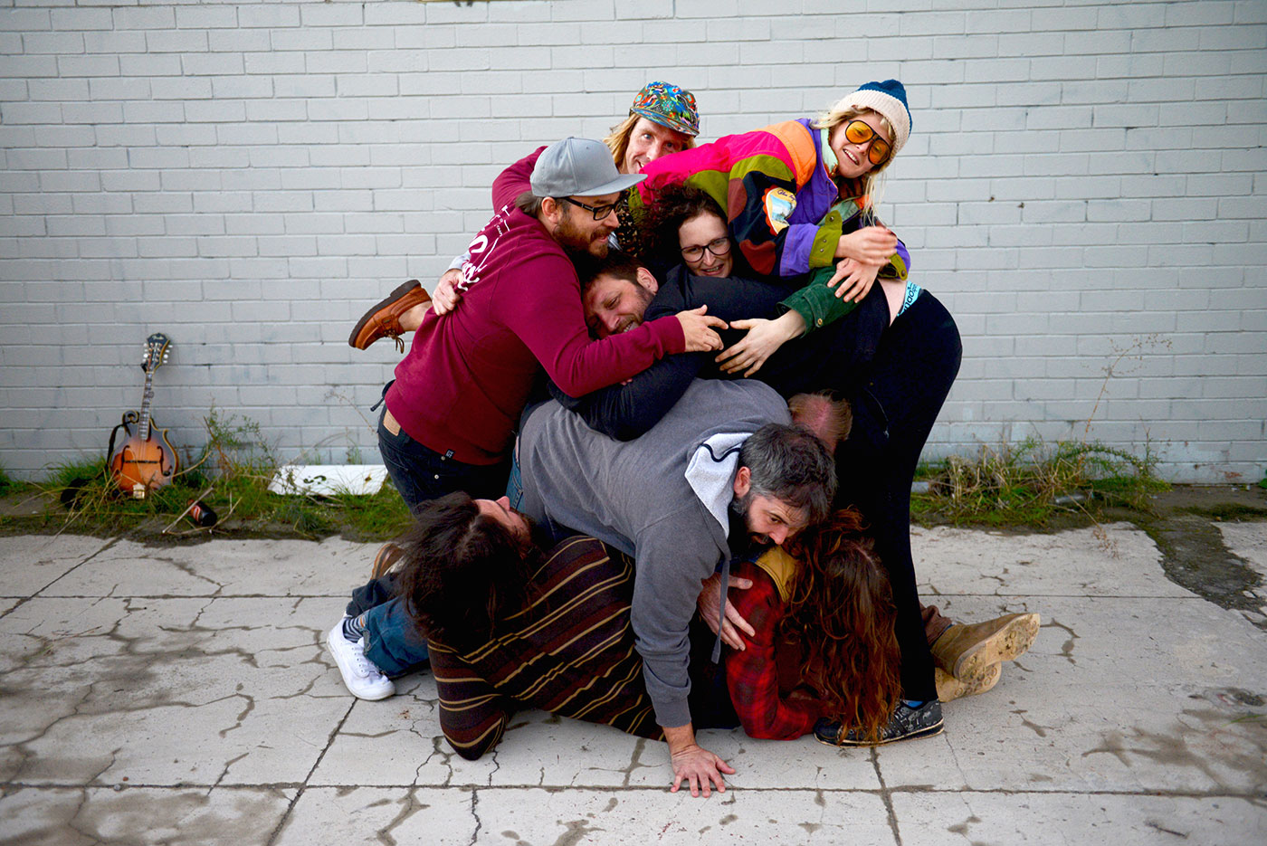 Band member pilled up on the ground on top of each other, horsing around